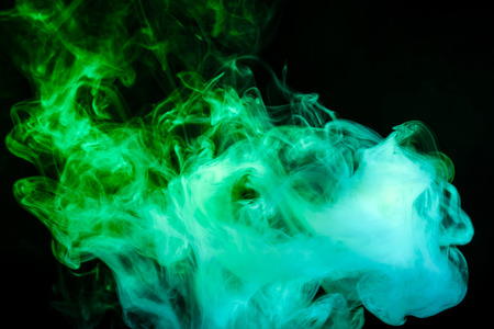 green cloud of smoke of  black isolated background. Background from the smoke of vapeの写真素材