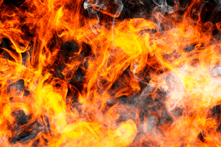 Thick fiary smoke on a black isolated background. Fire flames background.  の写真素材