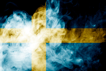 National flag of Sweden from thick colored smoke on a black isolated backgroundの写真素材