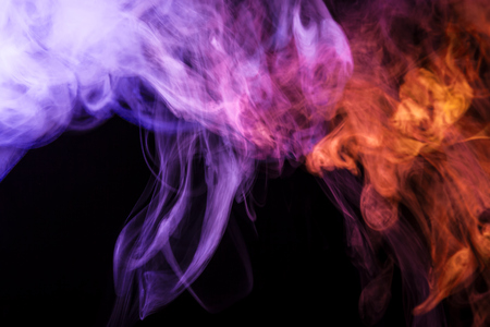 Colorful blue, pink and red smoke  on a black isolated background. Background from the smoke of vape
の写真素材