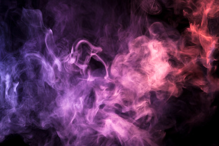 Cloud of red and pink smoke on a black isolated background. Background from the smoke of vape
の写真素材