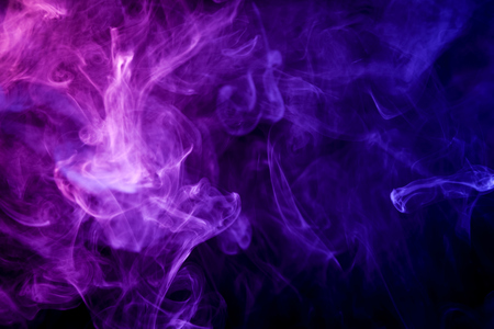 Thick colorful blue and pink  smoke on a black isolated background. Background from the smoke of vape