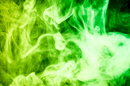 Colorful green smoke  on a black isolated background. Background from the smoke of vapeの写真素材