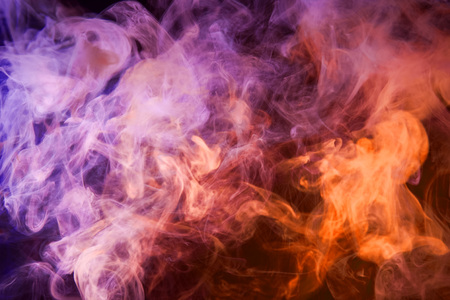 Colorful pink and orange smoke  on a black isolated background. Background from the smoke of vape
の写真素材