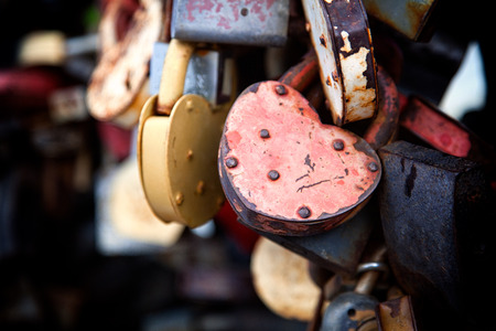 Close-up of the pink and other lock in the form of hearts on the old city bridge, the tradition of lovers on the wedding dayの写真素材