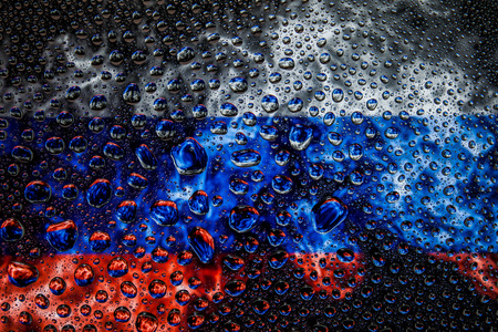 Close-up of a drop of water against a background of the national flag of  Russia on an isolated backgroundの写真素材