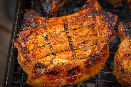 A close-up of the pies of entrecote pork in teriyaki sauce is fried in a grill. Preparation of a shish kebab on a summer day at the cottageの写真素材
