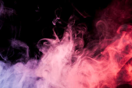 Colorful pink and red smoke  on a black isolated background. Background from the smoke of vapeの写真素材