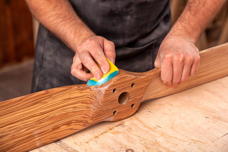 Experienced carpenter in work clothes and small buiness owner working in woodwork workshop,  using...