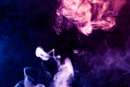 pink and blue smoke on a black isolated background. Background of smoke vapeの写真素材