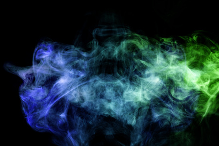 Cloud of blue and green smoke on a black isolated background. Background from the smoke of vapeの写真素材