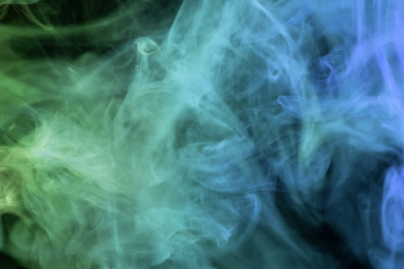 Dense multicolored smoke of   blue and green colors on a black isolated background. Background of...