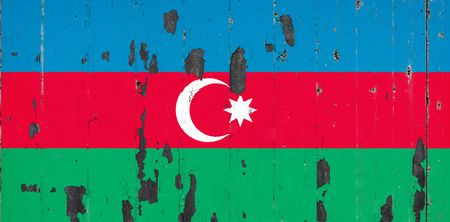National flag of Azerbaijan on the background of an old mettale covered with peeling paintの写真素材