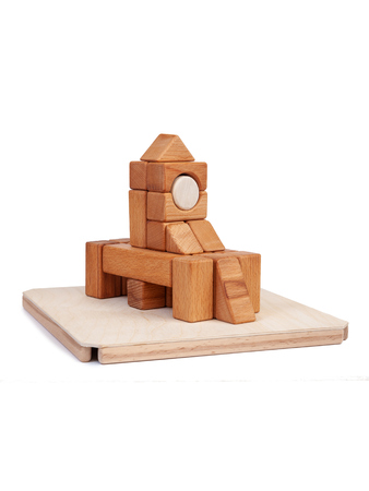 Photo wooden constructor of small cubes, triangles, balls and other forms of beech on a white isolated background. Wooden designer, built in the shape of the castleの写真素材