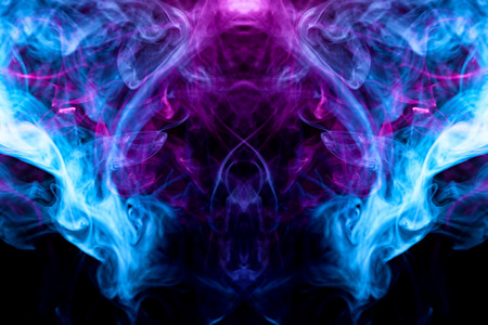 Fantasy print for clothes: t-shirts, sweatshirts.  Colorful pink and blue smoke in the form of a skull, monster, dragon on a black isolated background. Background from the smoke of vapeの写真素材
