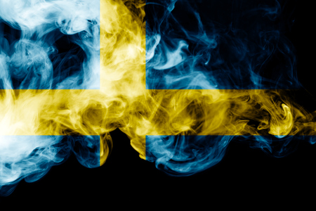 National flag of Sweden from thick colored smoke on a black isolated backgroundの写真素材