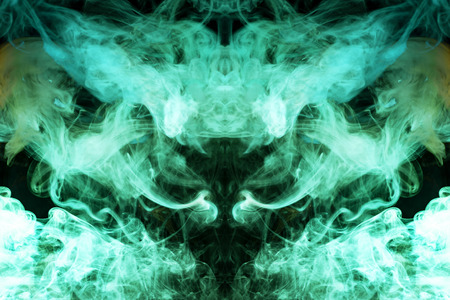 Mocap for cool t-shirts. Thick colorful green and yellow smoke  in the form of a monster on a black isolated background. Background from the smoke of vape.の写真素材