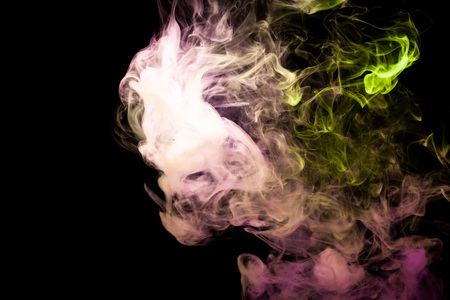 Cloud of yellow and purple smoke on a black isolated background. Background from the smoke of vapeの写真素材