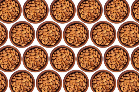 Peeled  almond  in a wooden cedar plate on a white isolated background. Row of bowls with almond ...