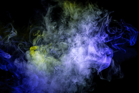 Thick colorful blue and green smoke  in the form of a butterfly on a black isolated background. Background from the smoke of vape. Mocap for cool t-shirtsの写真素材