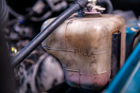 Close-up antifreeze expansion tank under the hood of the car. Low level of antifreeze in the car.の写真素材