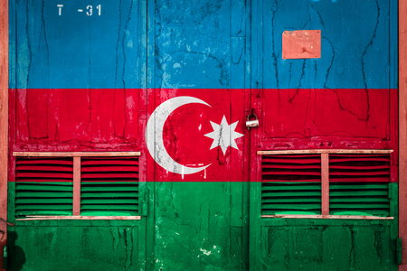 Close-up of old warehouse gate with national flag of Azerbaijan. Concept of Azerbaijan export-import, storage of goods and national delivery of goods. Flag in grunge styleの写真素材