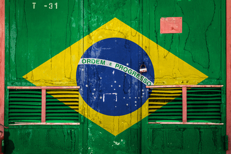 Close-up of old warehouse gate with national flag of Brazil. Concept of Brazil export-import, storage of goods and national delivery of goods. Flag in grunge styleの写真素材