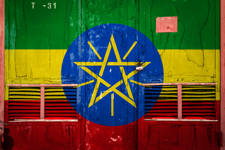 Close-up of old warehouse gate with national flag of Ethiopia. Concept of Ethiopia export-import, storage of goods and national delivery of goods. Flag in grunge styleの写真素材