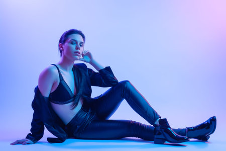 High Fashion model  woman in fashion t-shirts in colorful bright neon uv blue and pink lights, posing in studio. Fashion concept and Zine cultureの写真素材