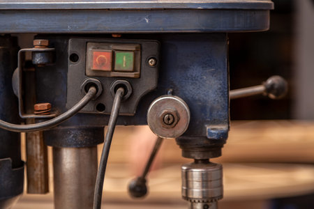 Close-up switch on industrial Iron drill ready for work in workshop interior. Close up on the drilling machineの写真素材