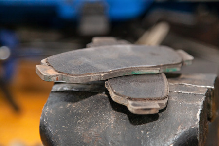 A set of two old automobile brake pads on a garage.の写真素材
