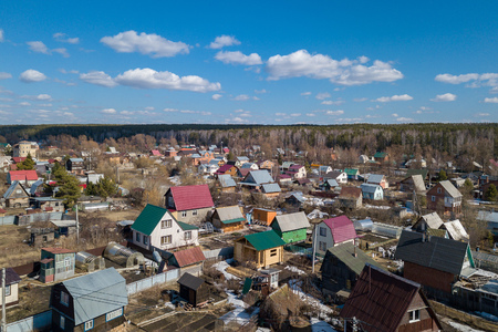 Aerial photography of a a cottage village with colorful houses, road, green trees and yards. Helicopter drone shotの写真素材