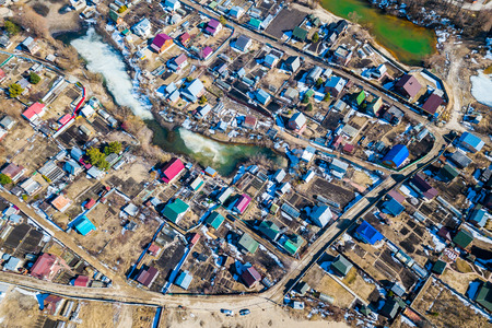 Aerial photography of a a cottage village with colorful houses, road, green trees and yards. Helicopter drone shotの写真素材