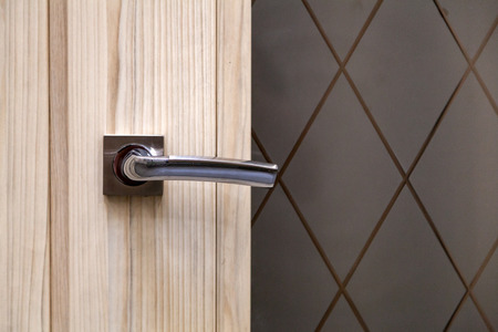Steel door, wood trim. Several locks and a handle. Hotel door with modern knob for background.の写真素材