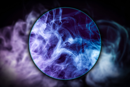 Close-up  swirling  Ñloud of pink and blue smoke  blown under a magnifying glass on black isolated backgroundの写真素材