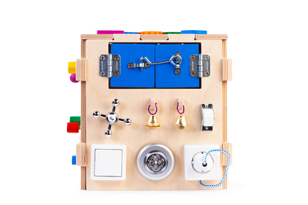 Wooden eco-friendly busy board house - educational toy for children, babies on a white isolated background, consisting maze, gear, sorter, switches, sockets, water mixers, bellの写真素材
