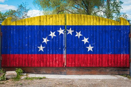 Close-up of the national flag of Venezuela on a wooden gate at the entrance to the closed territory on a summer day. The concept of storage of goods, entry to a closed area, tourism in Venezuelaの写真素材