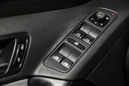 Ð¡lose-up of the car  black interior. Side door buttons: window adjustment, door lock and  side mirror adjustment buttons.  modern car interiorの写真素材