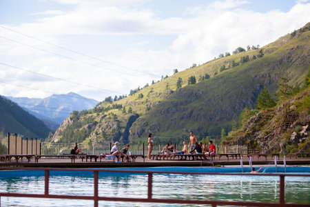 Altai, Russia â August 08, 2018:  The company of children and teenagers in summer clothes and swimsuits rests and bathes in the pool at the summer international camp in the Chemal region, Altai Territoryのeditorial素材