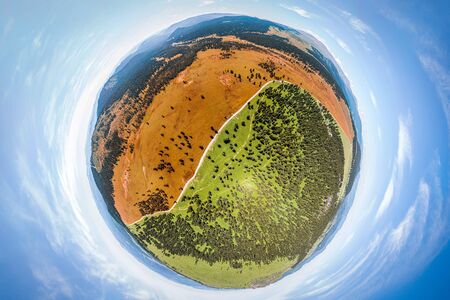 Helicopter drone shot. Aerial photography of a green field, mpuntain and forest. Panoramic city 360  shot from aboveの写真素材