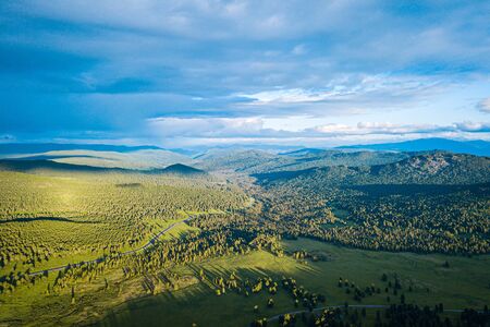 Ultra wide panorama of skyline. Green mountains covered with forest on the blue sky background.  Amazing view on green mountains from a viewpointの写真素材