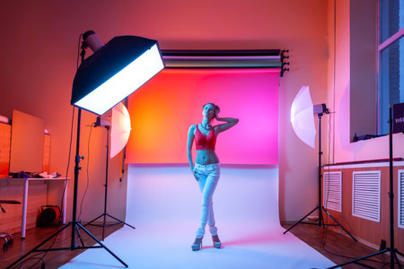 Backstage: model woman with in underwear,  jeans posing in attractive position in colorful bright...