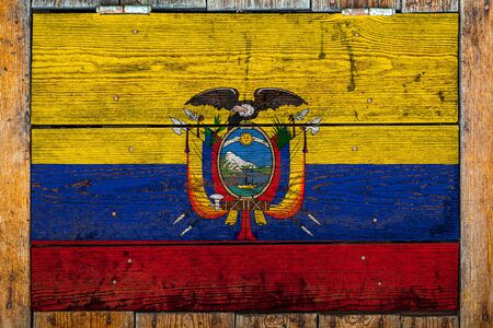 National flag of Ecuador on a wooden wall background.The concept of national pride and symbol of the country.Flag painted on a wooden fence with metal nails.の写真素材