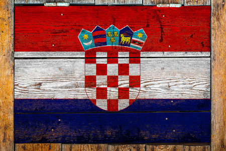 National flag of Croatia on a wooden wall background.The concept of national pride and symbol of the country.Flag painted on a wooden fence with metal nails.の写真素材