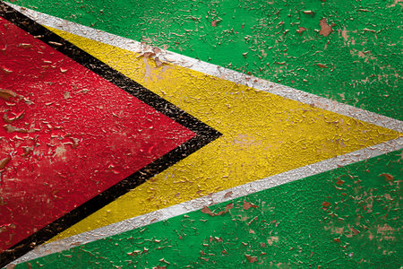 National flag of Guyana on old peeling wall background.The concept of national pride and symbol of the country.の写真素材