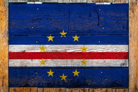 National flag of Cape Verde on a wooden wall background.The concept of national pride and symbol of the country.Flag painted on a wooden fence with metal nails.の写真素材