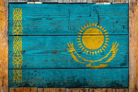 National flag of Kazakhstan on a wooden wall background.The concept of national pride and symbol of the country.Flag painted on a wooden fence with metal nails.の写真素材