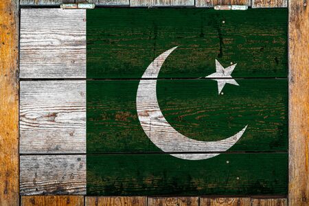 National flag of Pakistan on a wooden wall background.The concept of national pride and symbol of the country.Flag painted on a wooden fence with metal nails.の写真素材
