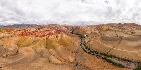 stunning view of the high mountains with red sand, crevices, the river flows nearby. Beautiful view...