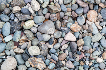 Close-up of river stones multi-colored gray, brown, white colors. texture, pattern of stones of...